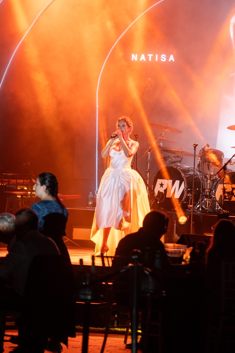A singer performing on the BIG ART Festival stage at Romazzino