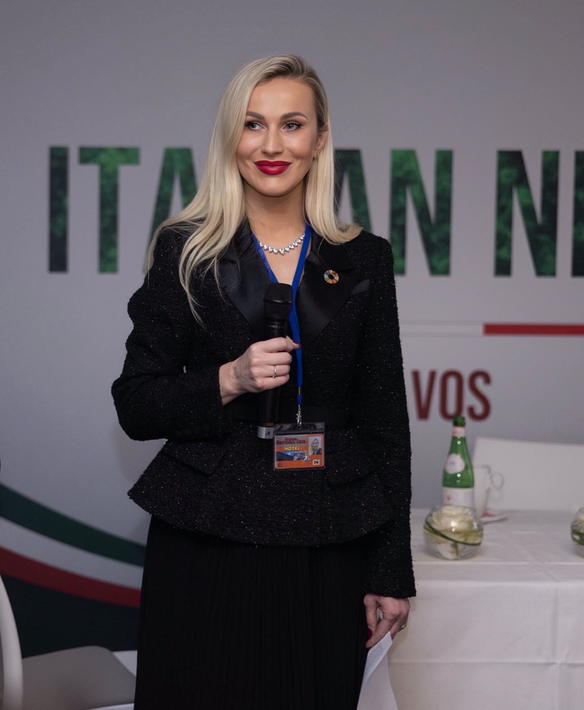 Irina Biss speaking with a microphone at an Italian pavilion event in Davos